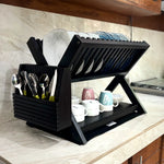Wood Ceylon black wooden dish drying rack with two tiers holding plates, cups, and utensils on a kitchen counter