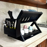 Wood Ceylon black wooden dish drying rack with two tiers holding plates, cups, and utensils on a kitchen counter