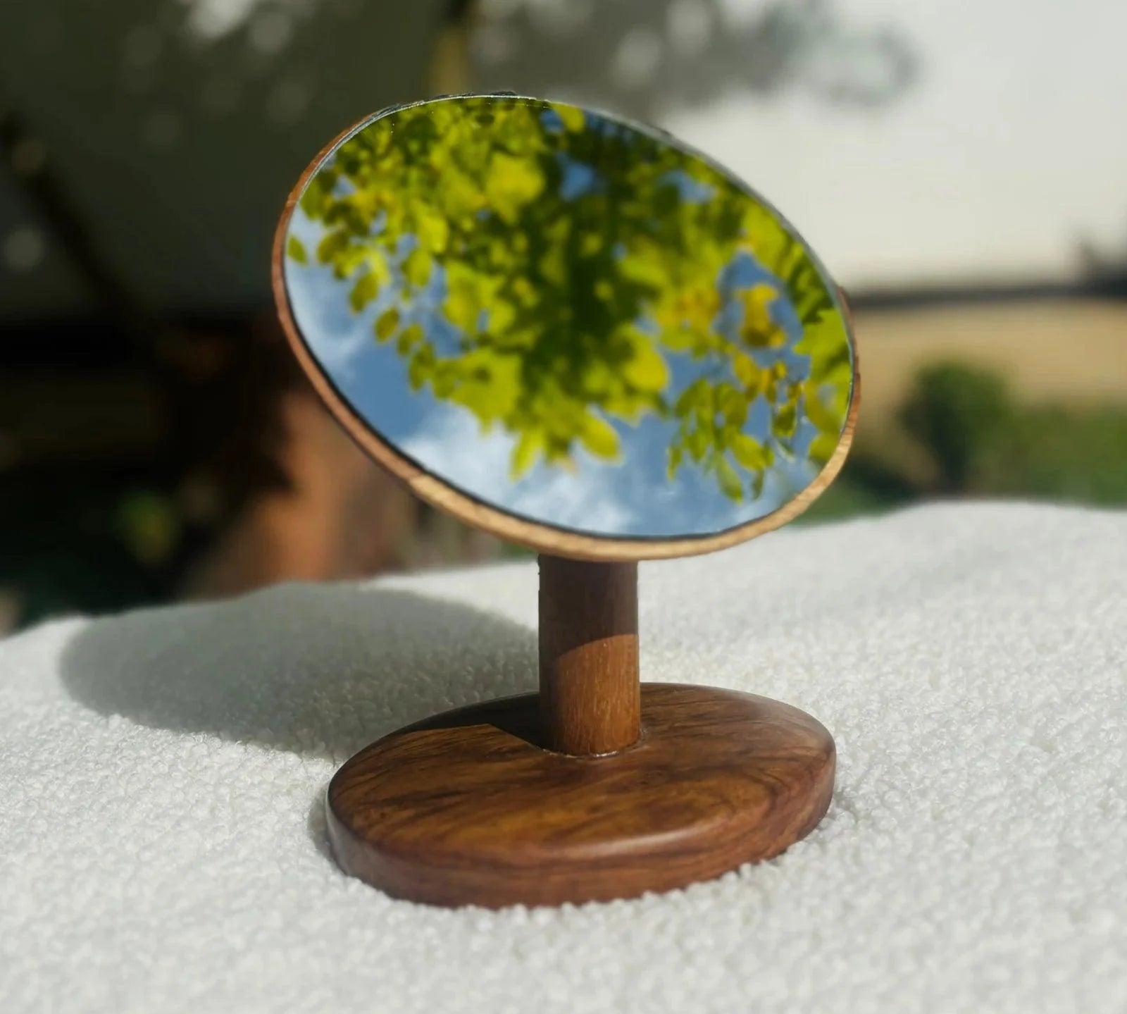 Wood Ceylon tabletop vanity mirror teak with round reflective surface and wooden base on white cloth