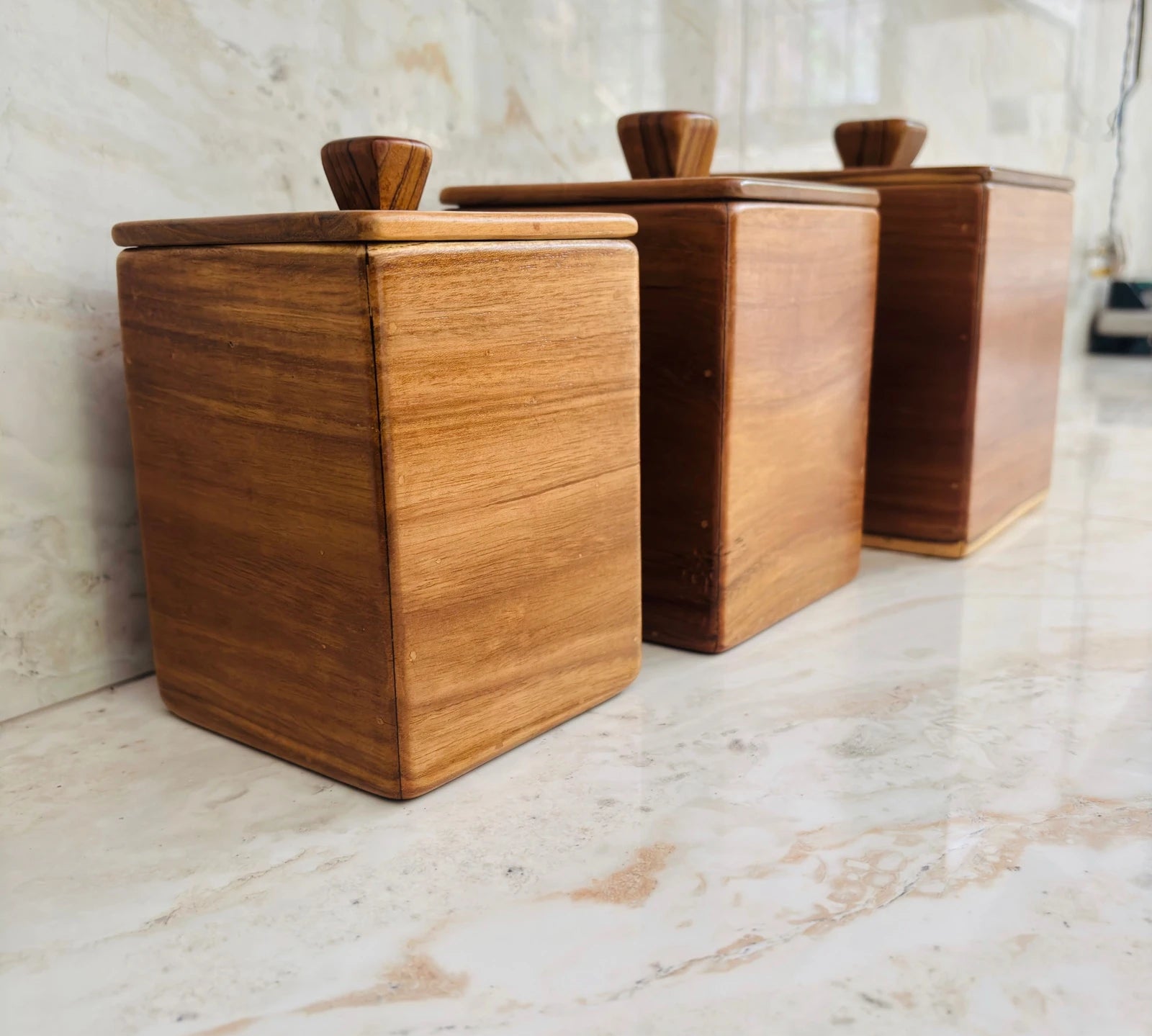 Wood Ceylon kitchen canister set of 3 made of smooth natural wood with lids on marble countertop