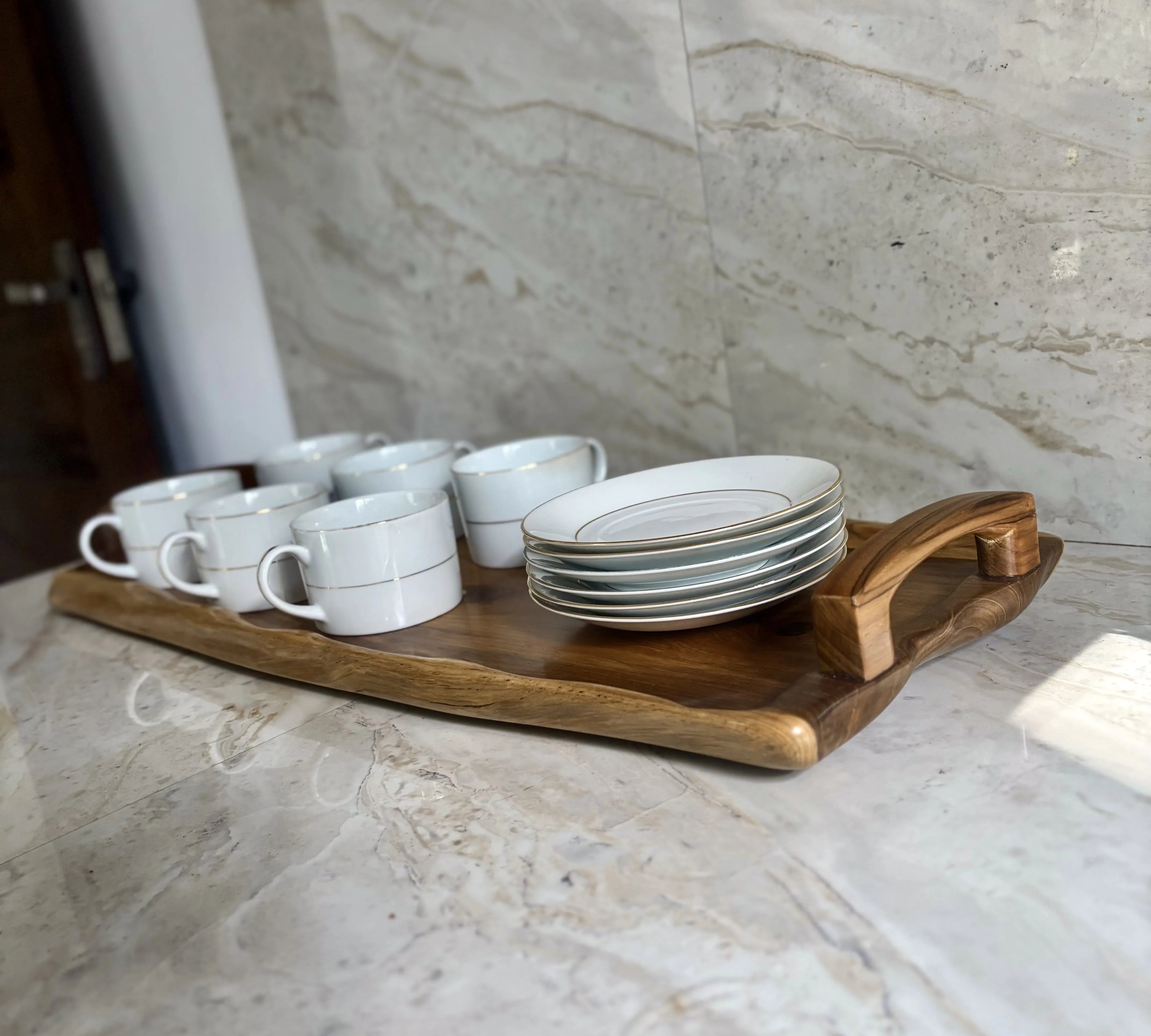 Wood Ceylon wooden serving tray with handle holding white cups and stacked plates on marble surface