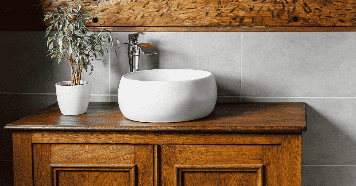 Rustic small bathroom vanity with a round white vessel sink and a potted plant on wooden countertop