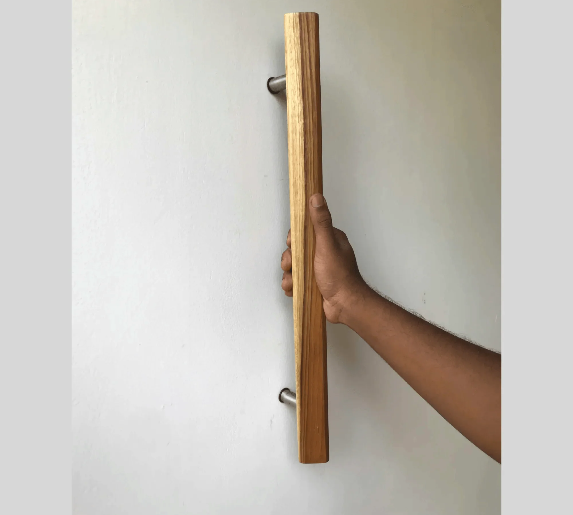 Hand holding a Wood Storm Door Handle mounted on a white door by Wood Ceylon